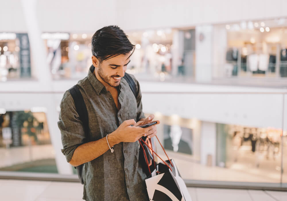 Shopper in mall looking at smartphone