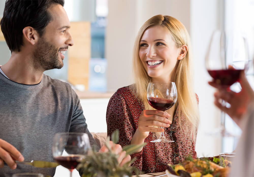 Couple drinking wine and eating food at a table
