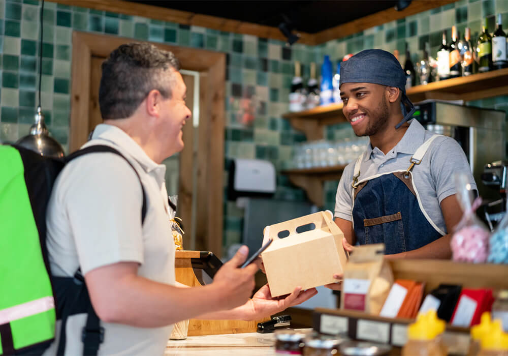 Server giving food to customer in takeout box