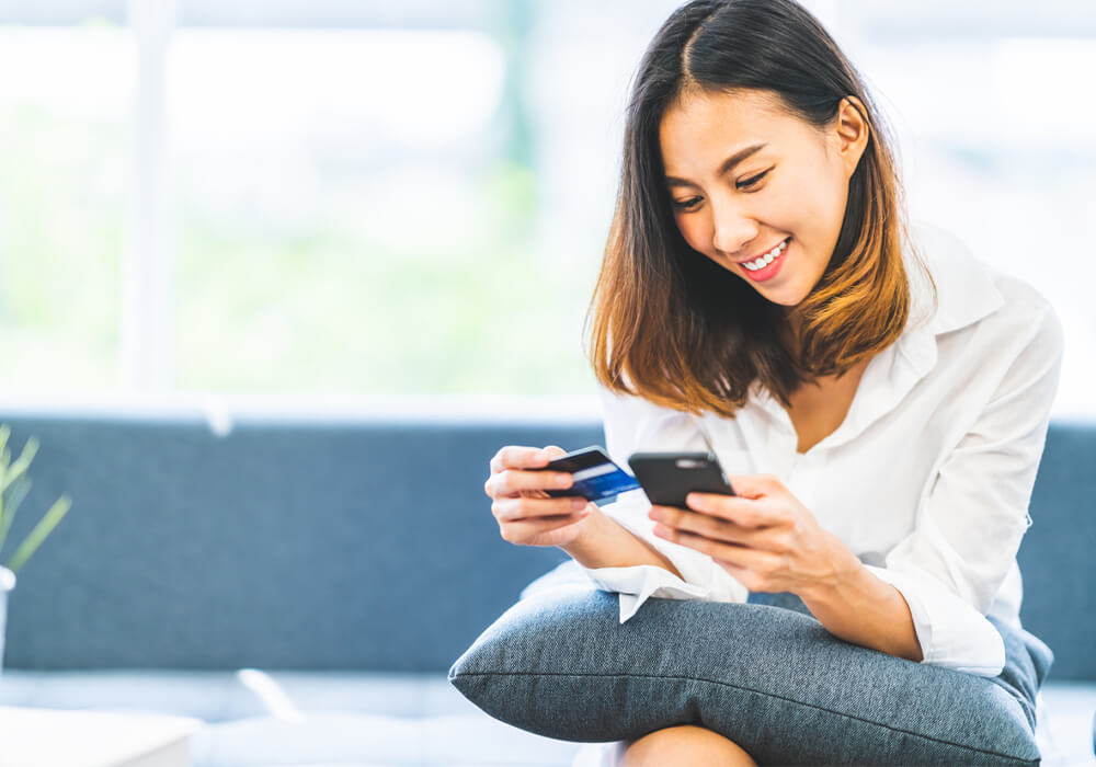Online shopper looking at credit card and smartphone