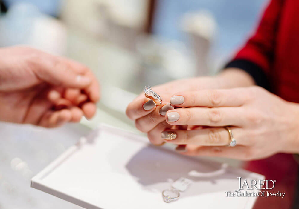 Jared the Galleria of Jewelry logo with image of Associate handing engagement ring to customer