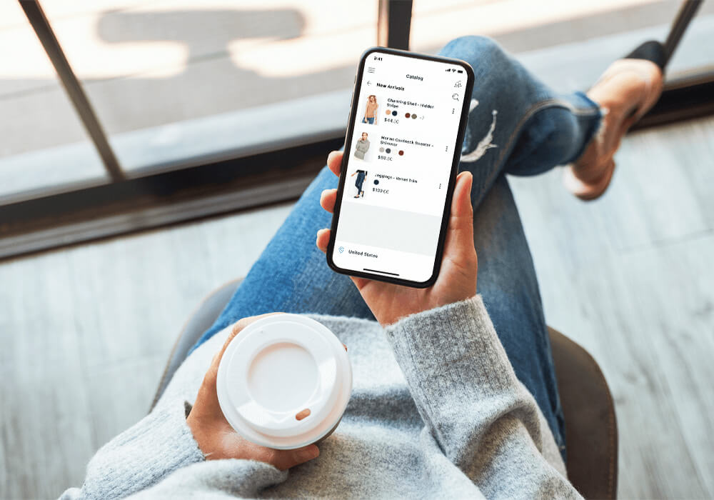 Customer sitting with coffee and shopping on their mobile device