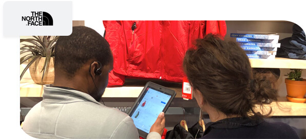 The North Face logo, with picture showing associate assisting customer with mobile POS