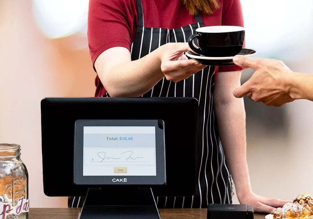 CAKE Point of Sale with Server handing coffee to customer