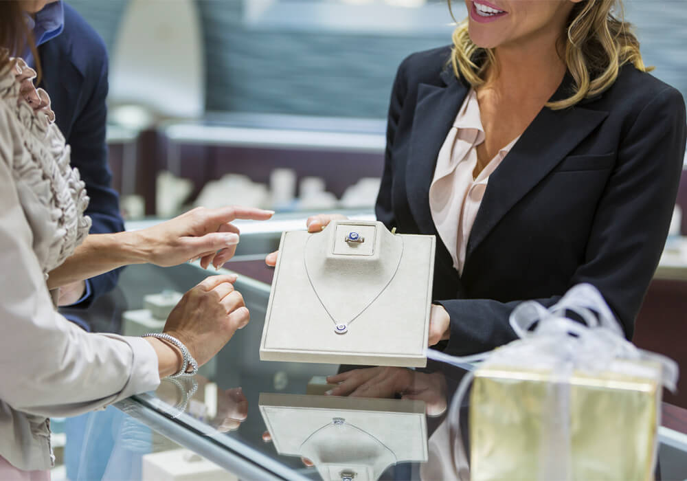 Associate showing necklace and ring to customer