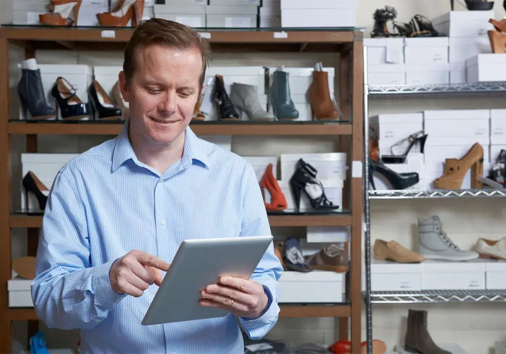 Shoe store associate using a tablet.
