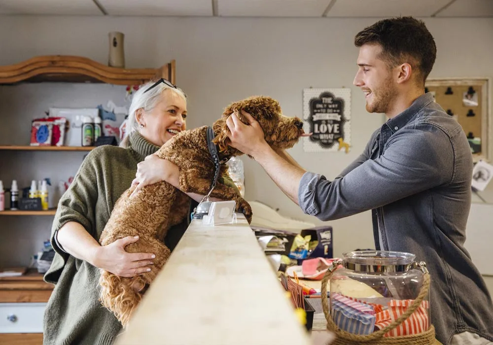 Pet store interaction with dog, associate, and customer