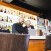 Bar Managers with POS and integrations looking at laptop